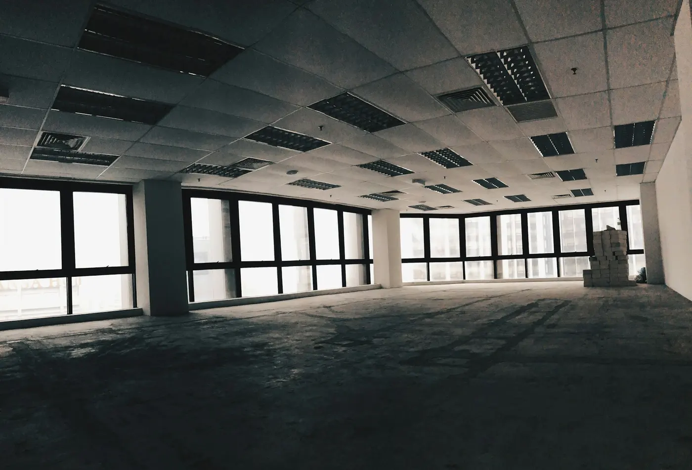 An empty open-plan office floor with large windows and nobody in it